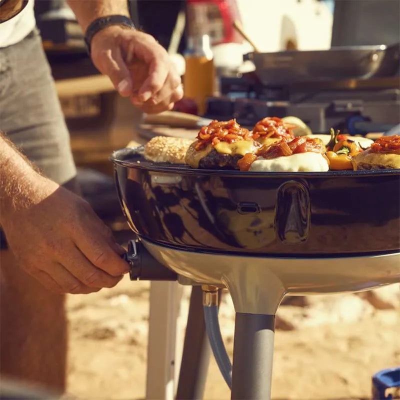 Person grilling food on a portable grill outdoors